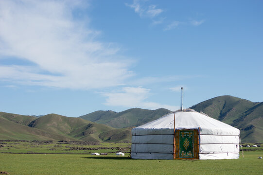 Ger standing alone on the grassland beneath distant hills, Orkhon Valley, Mongolia