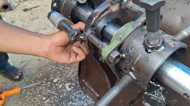 Mechanic using an Allen key to tighten bolts on a heavy machinery component or line boring machine for industrial repair concept