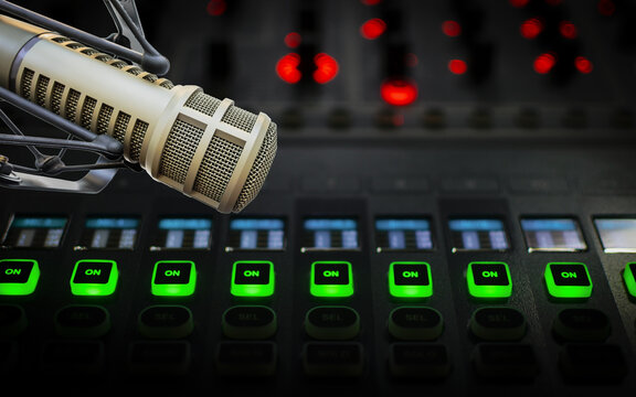 Broadcast microphone above illuminated audio mixer