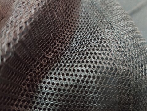 Macro shot of black perforated mesh fabric texture background