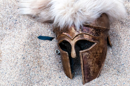Primer plano cenital de un antiguo casco griego corintio de bronce con un penacho de crines blancas, un art&iacute;culo de atrezo utilizado en ferias medievales.