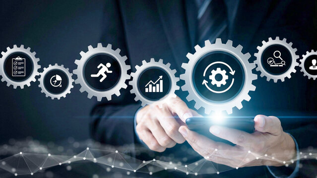 Professional businessman using smartphone with digital gear icons overlay for business process optimization and corporate management strategy concept