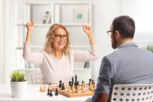 Mature woman winning a chess game against a man