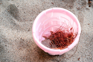 Pink bucket on sandy beach © Tricia