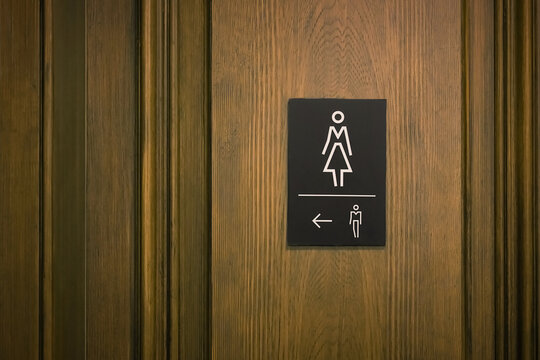 Hinweis auf eine &ouml;ffentliche Damentoilette mit einem Richtungspfeil zur Herrentoilette