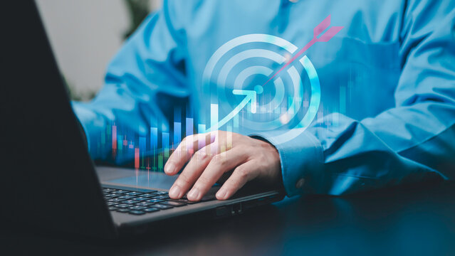 Financial planning, investment goals, trading strategy, business growth, profit and corporate success. Businessman using a laptop with a digital target, financial chart and upward market indicators.