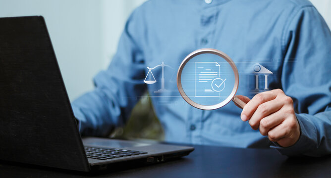 Auditing, banking compliance, financial investigation, law, risk assessment and verification. Businessman using a laptop and magnifying glass to examine financial documents and legal information.