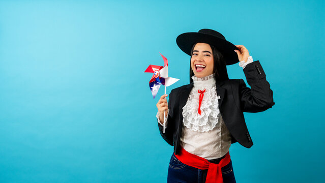 Happy woman holding a chilean flag pinwheel celebrating patriotic culture