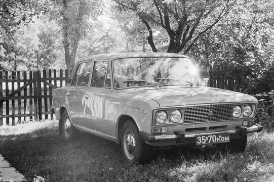 Vintage Soviet VAZ-2103 Lada car, black and white analog film photo.