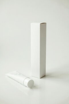 Blank white cosmetic tube and packaging box isolated on white background