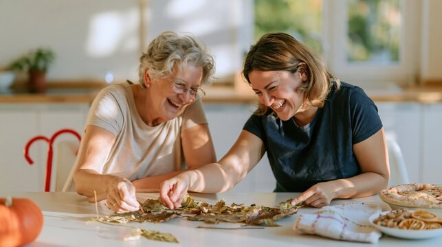 Autumn leaves sorted by color on a kitchen table by two women, a natural and warm seasonal scene for family and greeting cards