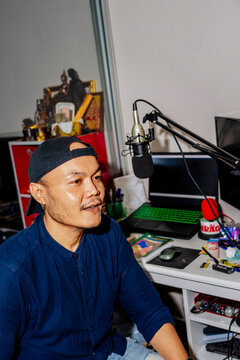 Podcast host at home studio With Computer Equipment and a Microphone
