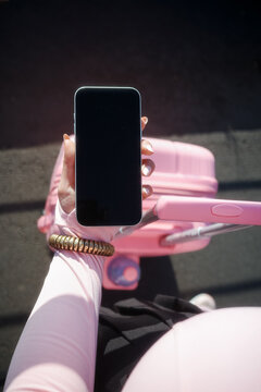 Hand holding blank smartphone in pink