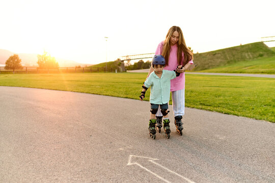 Mother Teaching Son to Roller Skate at Sunset