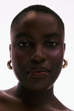 Model Poses With Earrings Against a Bright Background
