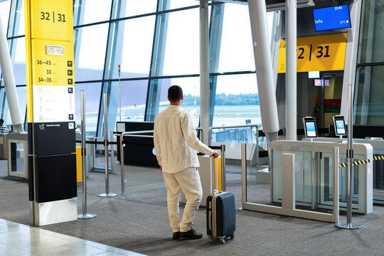 A man with a suitcase approaches the departure gate