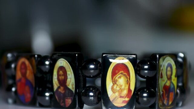 Close-up of a charm bracelet featuring a picture of Jesus Christ