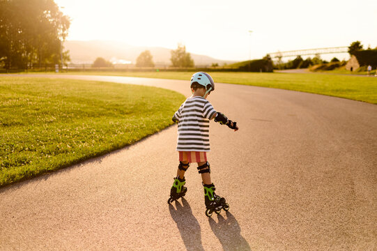 Child Learning to Roller Skate at Sunset