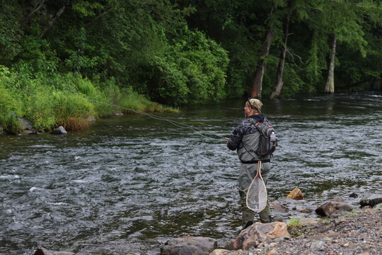 Fly Fisher Casting in a Forest River in Broken Bow, Oklahoma