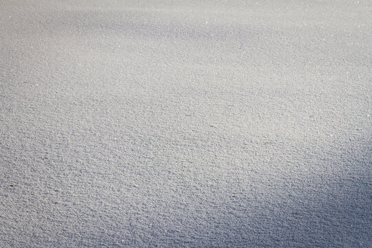Natural winter backdrop featuring white snow texture. Winter white snow surface as background.