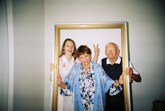 Senior Couple Poses With Adult Daughter for a Funny Photo