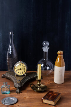 Various old vintage objects on brown wooden table by the black wall. Still life.