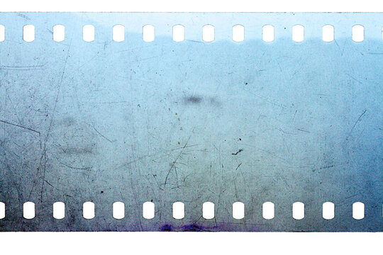 Dusty and grungy 35mm film texture or surface. Perforated scratched camera film isolated on white background.