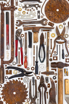 Flat lay of old hand tools on white background. Large collection of various rusty tools and bits arranged on white.