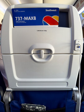 LAS VEGAS, NV, APR 28, 2026: Seatback tray table area showing a blue Southwest 737 MAX8 safety card, USB charging port, and tray latch mechanism