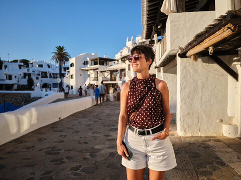 Woman enjoying evening walking through Binibeca Vell village