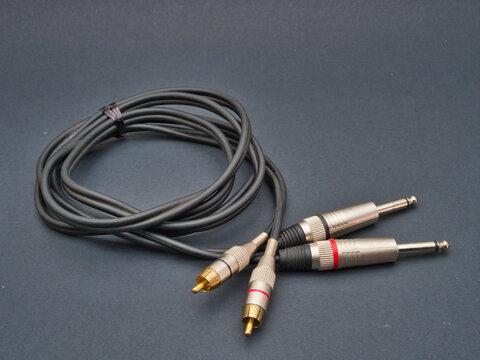 Audio Cable with Jack and RCA Connectors - A professional audio cable features two 1/4 inch jack plugs and two RCA plugs, designed for connecting sound equipment and electronics.