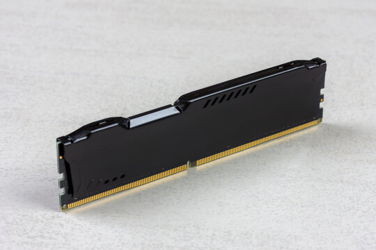 A RAM module with a black heatsink on a gray background, close‑up view