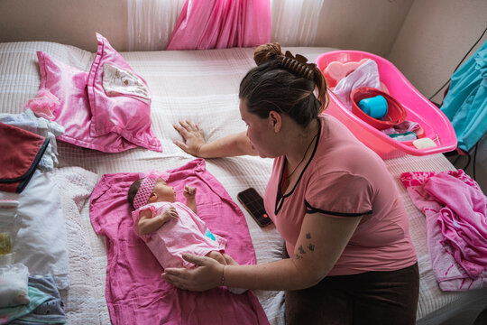 Mother caring for baby daughter on bed