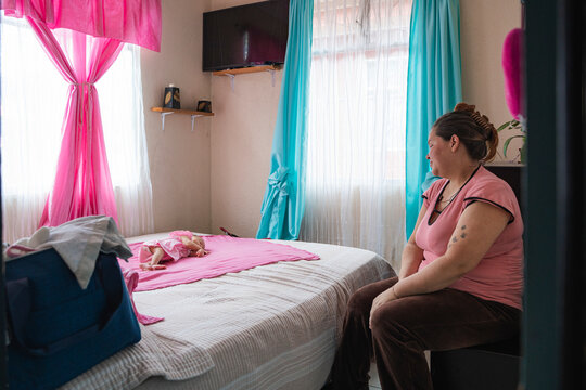 Mother watching sleeping baby in bedroom with colorful curtains