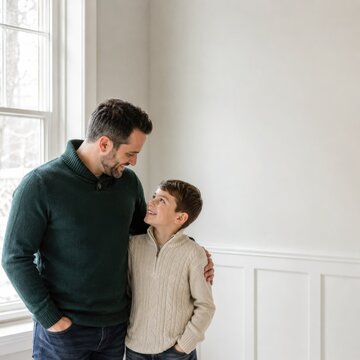 Father and son sharing a warm moment together in bright winter home interior with copy space
