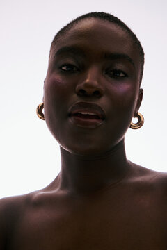 Woman With Earrings Posing Against a Light Background