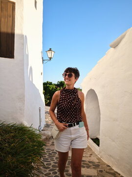 Woman exploring Binibeca Vell white village in Menorca
