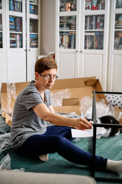Woman Assembling Flat Pack Furniture at Home
