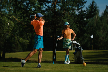 Obraz premium Golfers enjoying a sunny day on the course while practicing their swings and perfecting their putting techniques in a relaxing environment ideal for recreational golfing
