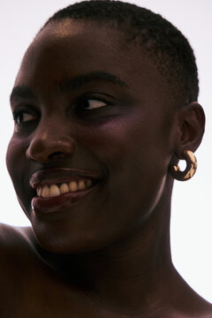 Smiling Woman Wears Earrings With Simple Background