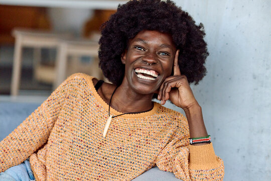 Woman Sits Casually on a Couch With a Happy Expression