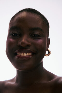 Smiling Person With Short Hair and Hoop Earrings in Bright Light