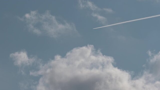Passenger airplane flying high in sky leaving condensation trail