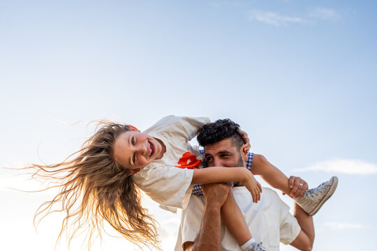 Carefree father and daughter playing beneath a blue sky