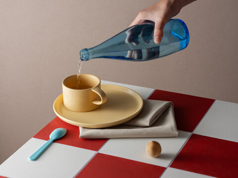 Pouring Water Into Cup on a red and white checkered surface
