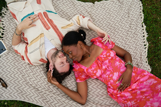 Interracial Couple Relax Together During Romantic Park Date