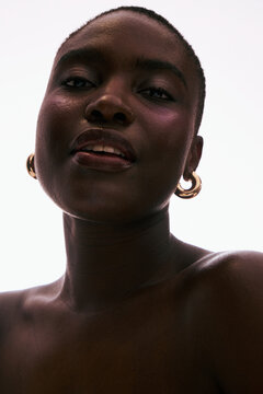 Woman With Earrings and Short Hair Smiling Softly at the Camera