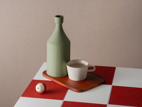 Still Life With Bottle and Cup on a checkered surface