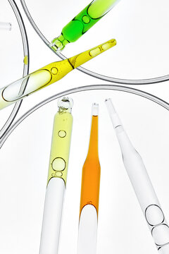 Laboratory Glass Pipettes with Colorful Liquids in Petri Dishes.