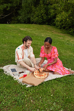 Interracial Couple Picnic Date in Park Sharing Pizza Outdoors